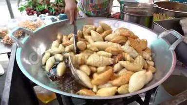 由小丑小刀鱼制成的鱼丸被街边的女摊贩炸了，泰国美食街风格。